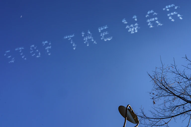 The words "stop the war" are written against a clear blue sky