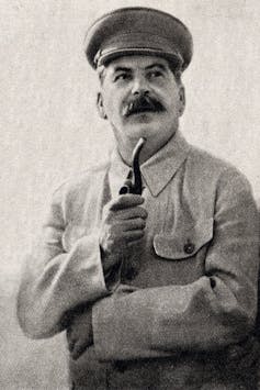 An official portrait of Stalin from the 1930s, showing him holding a pipe.