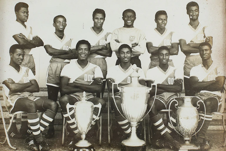 A line up of male footballers with trophies infront of them
