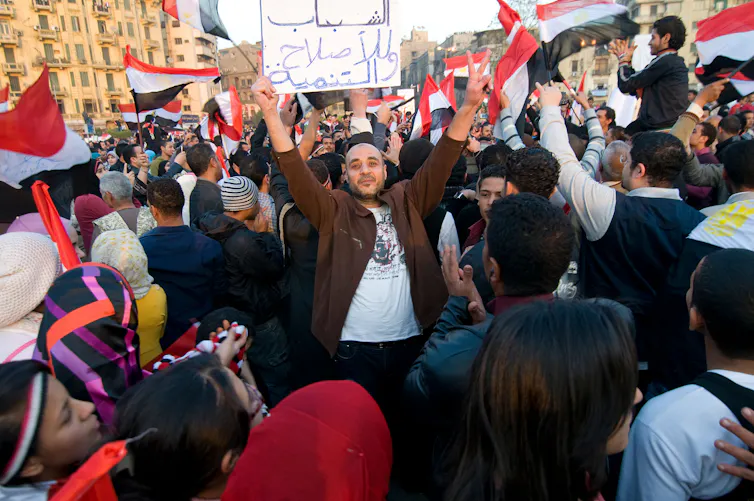 Protesters on the streets of Cairo waving Egyptian flags.