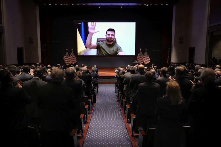 Ukrainian's President Volodymyr Zelenskyy waves his hand on a videolink with Congressmen and women gathered to hear him speak.
