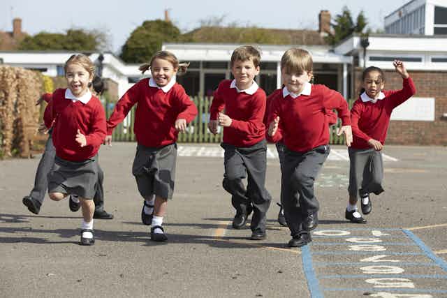 Five children in red and grey school uniforms.