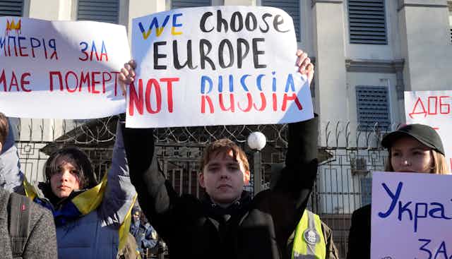A person holds a sign about their head that says "We Choose Europe Not Russia"