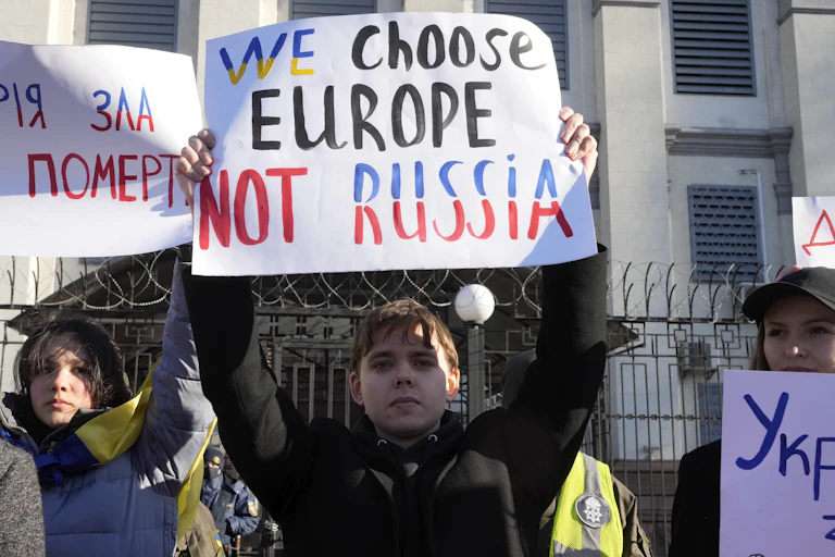 A person holds a sign about their head that says "We Choose Europe Not Russia"