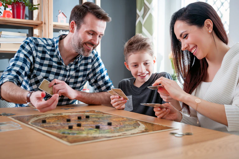 A father, son and mother play a board game