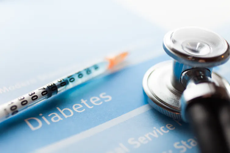 A syringe, stethoscope and paper with the word 'Diabetes' written across the type of it.