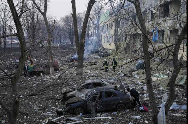 Image d'immeubles détruits, arbres morts et de véhicules incendiés