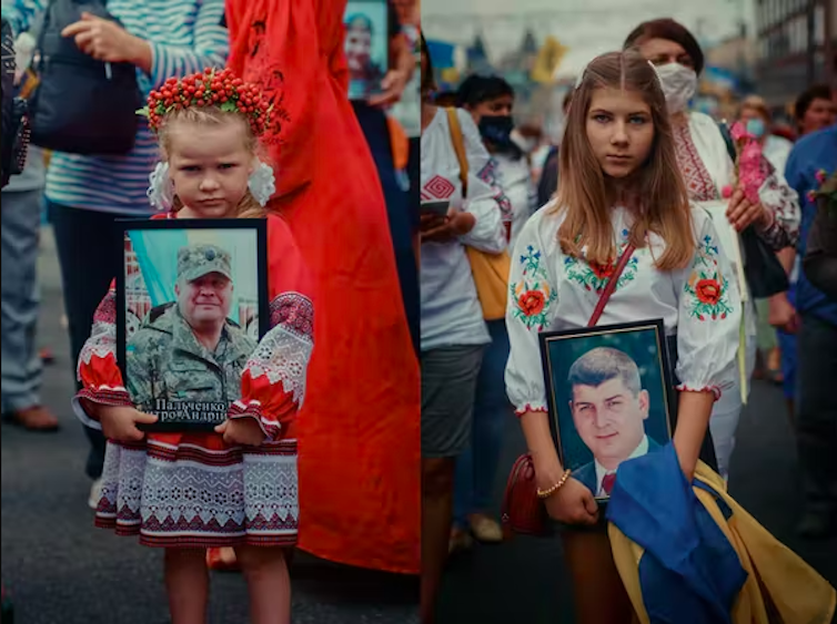 Two girls holding photographs