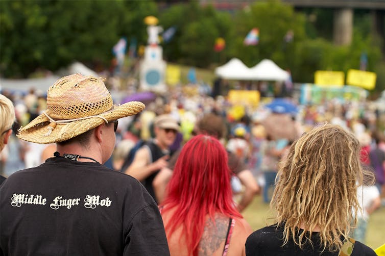 three people with crowd in background