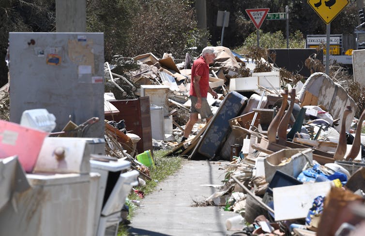 A local resident, walking through their flood affected belongings in Ipswich.