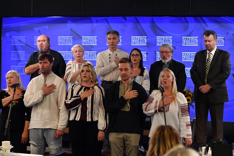 Members of the Ukrainian community sing the national anthem at the National Press Club in Canberra.