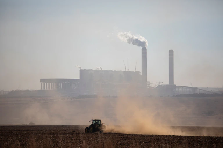 A tower emitting smoky gas in the air.