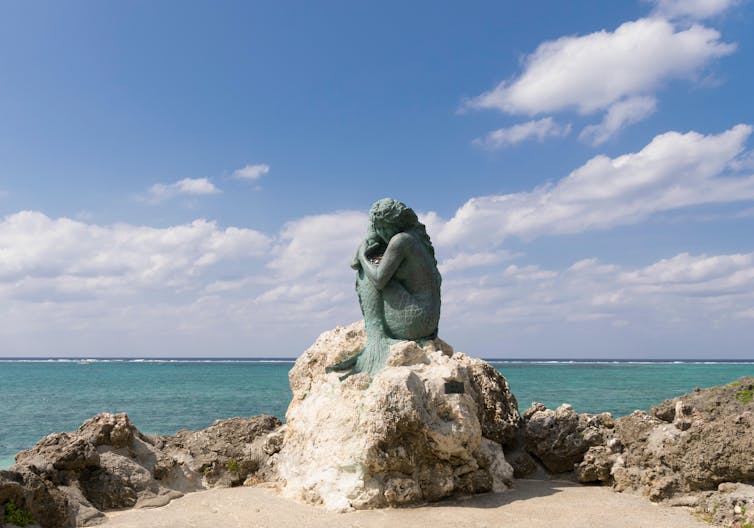 A bronze statue of a mermaid on Okinawa's Moon Beach.