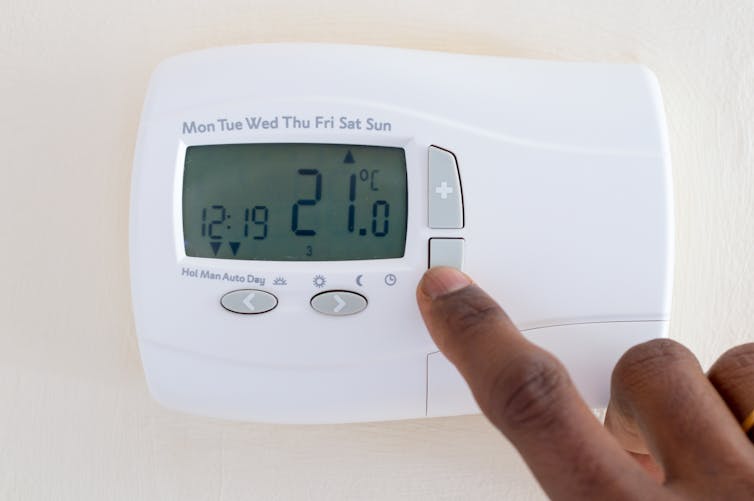 Finger points to thermostat