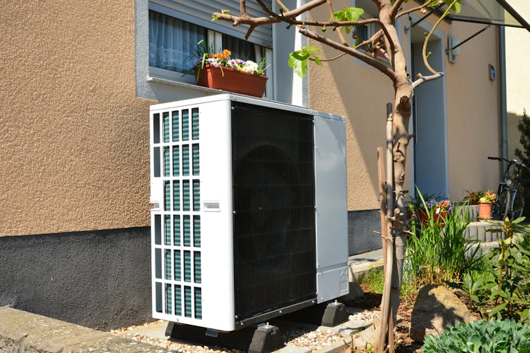 A large white-and-black fan unit outside an apartment window.