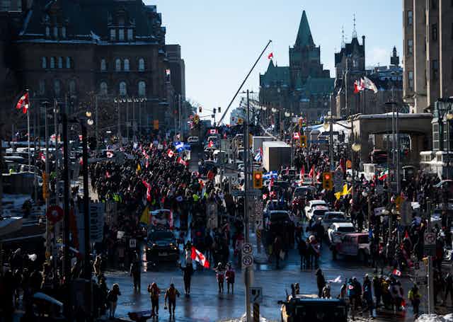A mass of people, cars and vehicles on Parliament Hill.