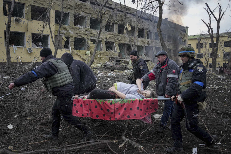 Pregnant women on stretcher being evacuated after hospital bombing