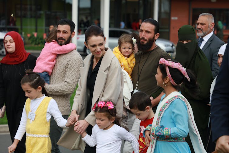 Prime minister Jacinda Ardern walks with children dressed in costumes from other countries.