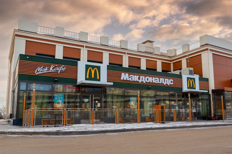 A McDonald's restaurant in Russia, with the golden arches and company name in Cyrillic.