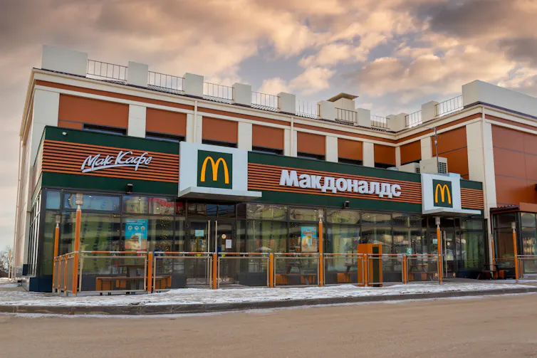 A McDonald's restaurant in Russia, with the golden arches and company name in Cyrillic.