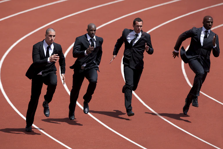 men in business suits run on a track