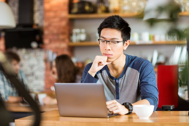 A young man works on a laptop.