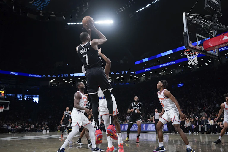 Kevin Durant taking a shot with other players around.