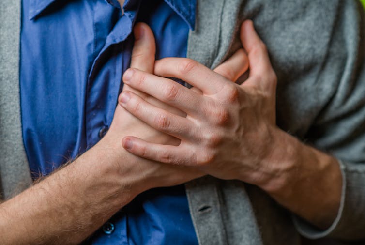 person clutches chest