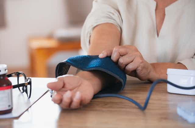woman take blood pressure test at desk