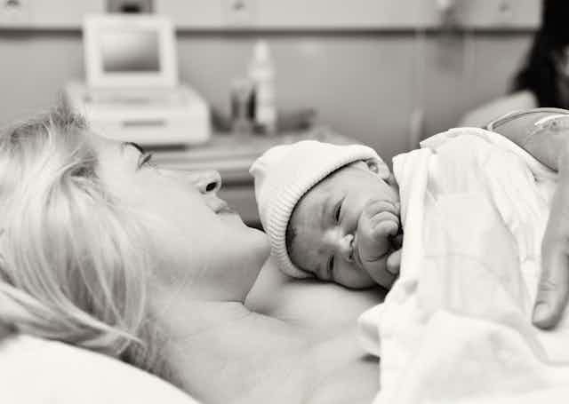 Black and white hospital scene,mother cuddling newborn