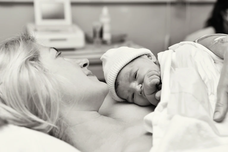 Black and white hospital scene,mother cuddling newborn