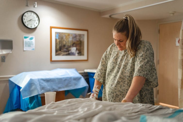 Woman leaning on hospital bed