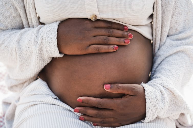 Woman holding pregnant stomach