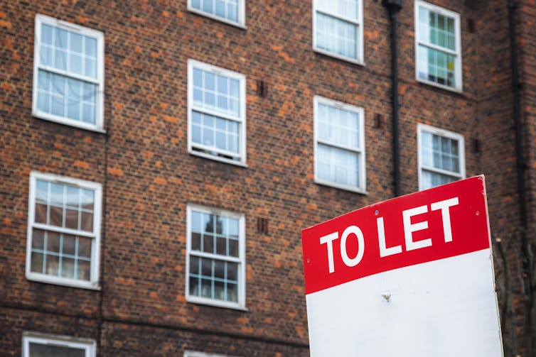 A To Let sign in front of a block of council flats