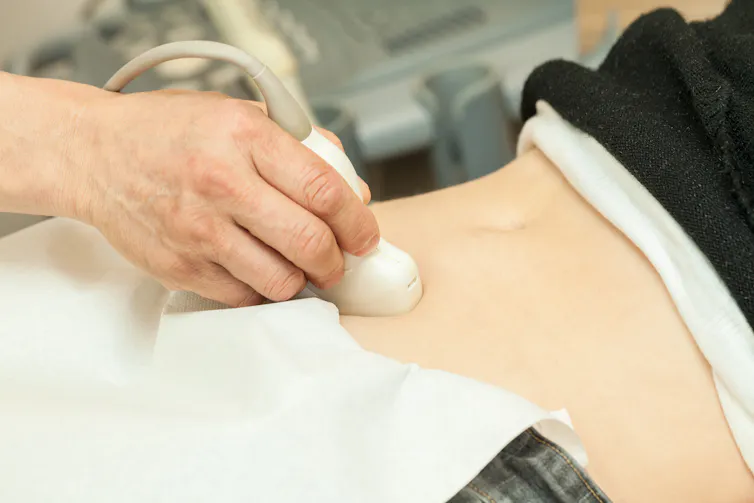 Close-up of person receiving abdominal ultrasound exam.
