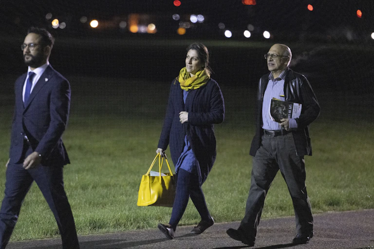 Nazanin Zaghari-Ratcliffe and Anoosheh Ashoori walking along an airport runway at night after arriving from Iran.