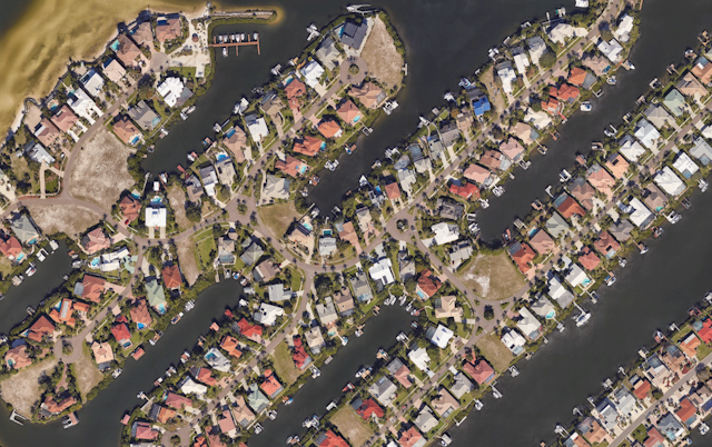 A satellite view of rows of tightly packed homes backing up to a maze of canals near Tampa Bay.