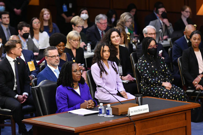 Judge Ketanji Brown Jackson arrives sits at a des.