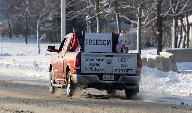 A truck with a sign that says "FREEDOM" on the back windshield