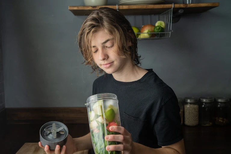 teen with fruit in blender