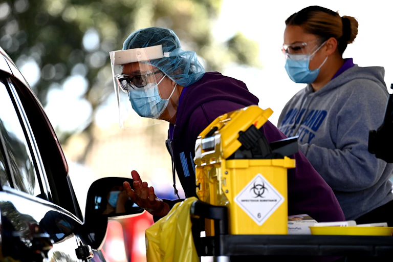 Nurses administering vaccines to people in cars