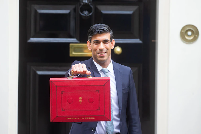 Rishi Sunak holding up his red briefcase outside No 10 Downing Street