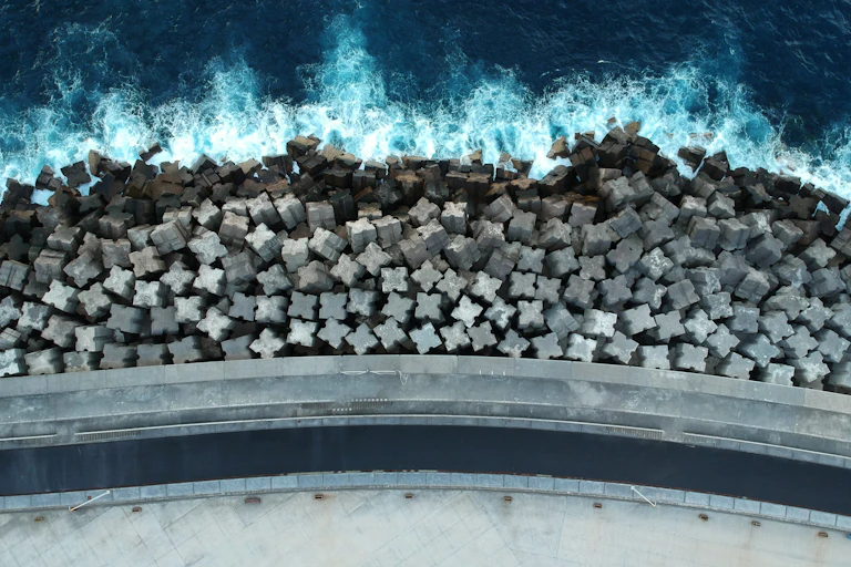 A coastal barrier made up of concrete blocks seen from above.