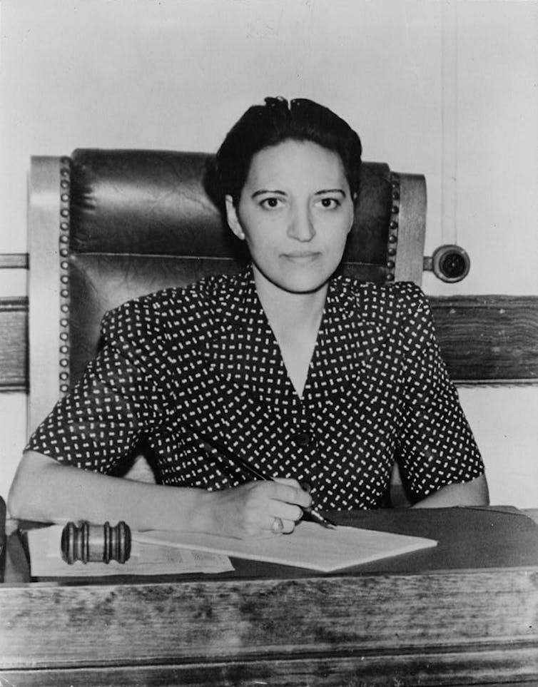 A woman sits at a desk