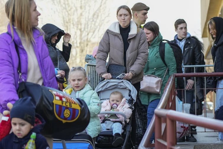 Mothers push baby strollers down a ramp.