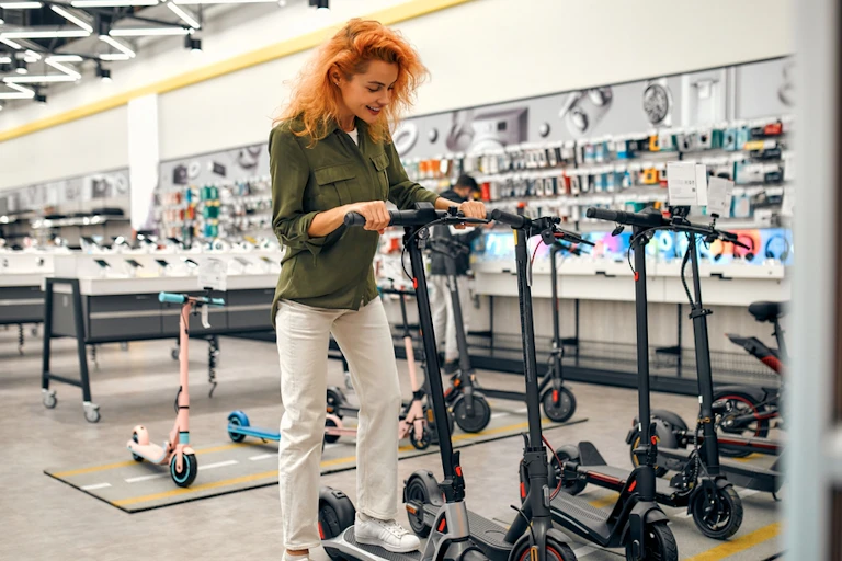Woman tries standing on e-scooter inside store