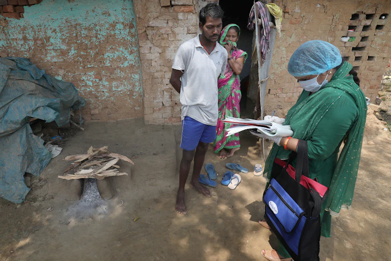 women in PPE talking to a couple