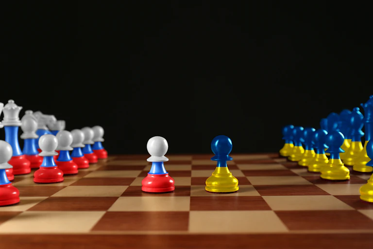 A chess board with pieces in the colours of Ukraine and Russia.