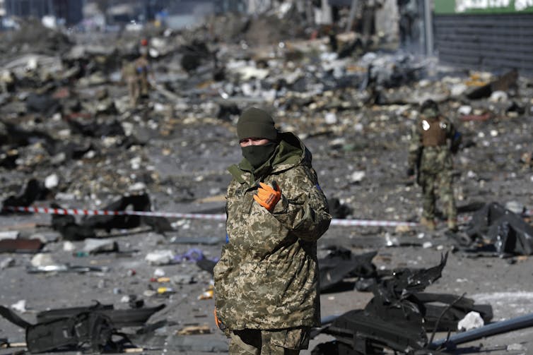 A Ukrainian solider in the rubble of a shopping centre.