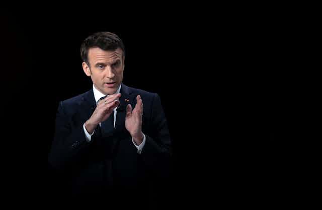 Emmanuel Macron with a black background. 